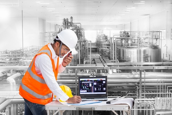 Industrial engineer checking machine status with computer